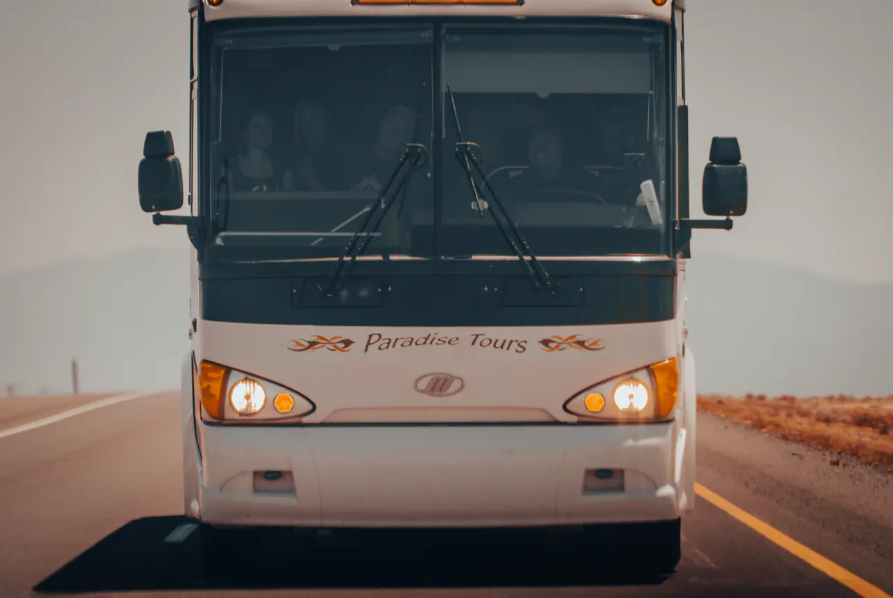 A white coach marked Paradise Tours comes down an empty highway