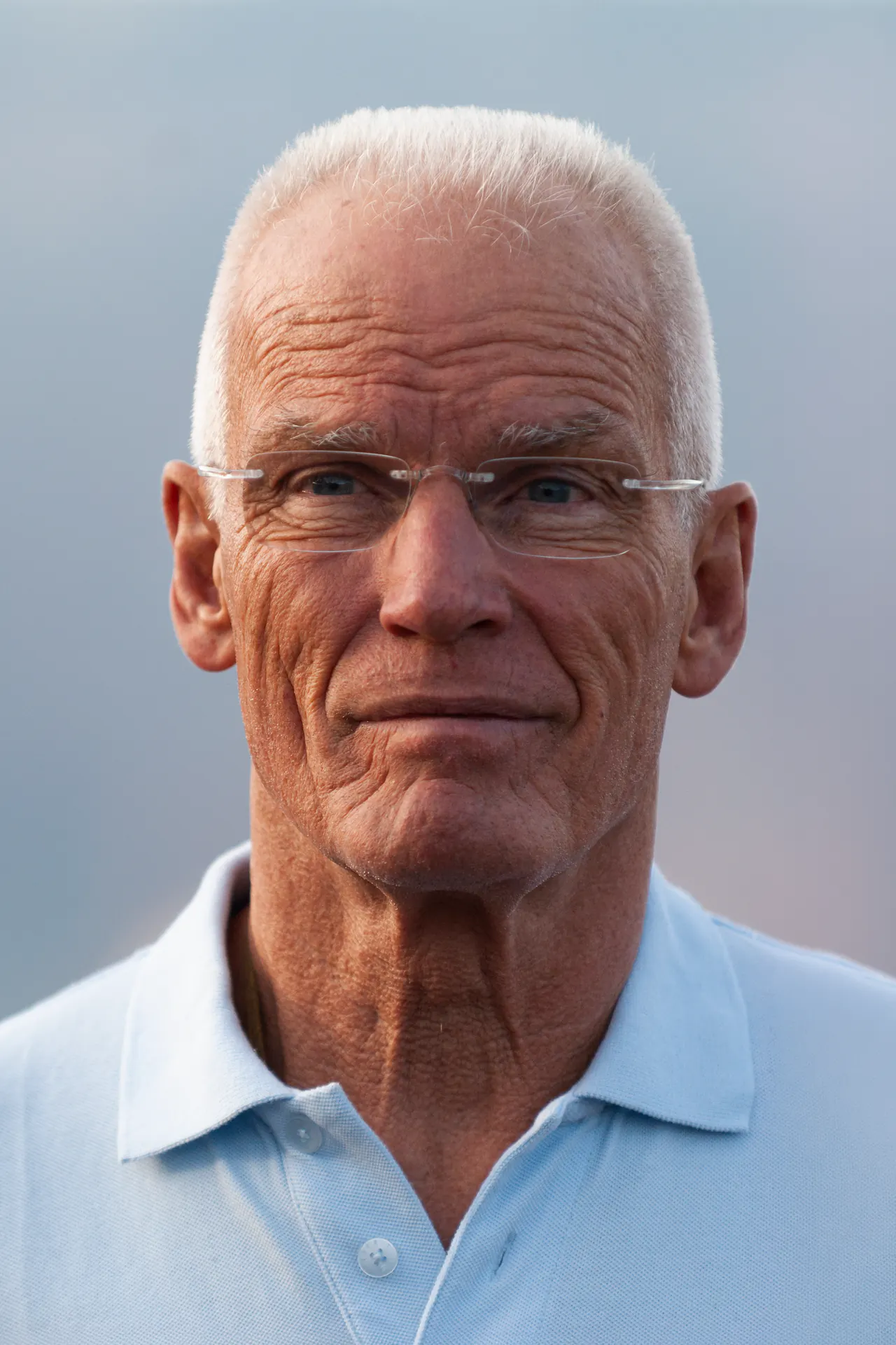 Portrait of Lama Ole Nydahl in a white polo shirt, looking into the camera