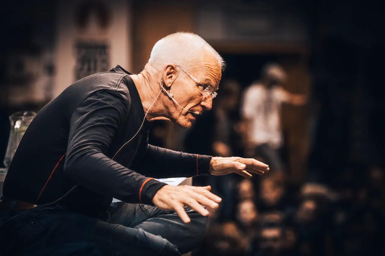 Lama Ole Nydahl leans forward with an outstretched hand while teaching