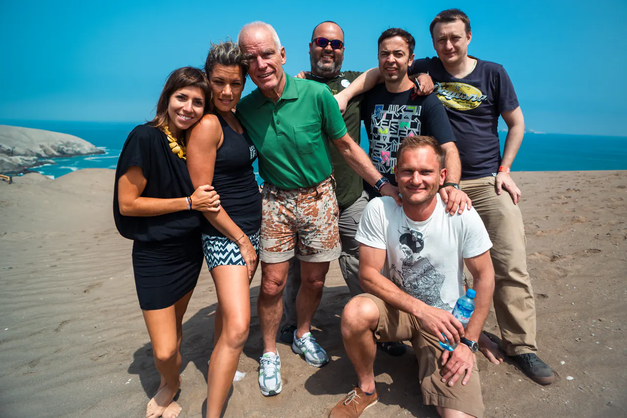 Lama Ole Nydahl poses with a group of friends on a sandy beach